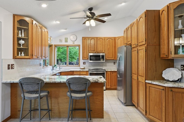 1378 Dunsmore Dr, Waconia, MN 55387 - kitchen with stainless steel appliances, a peninsula, a sink, decorative backsplash, and vaulted ceiling
