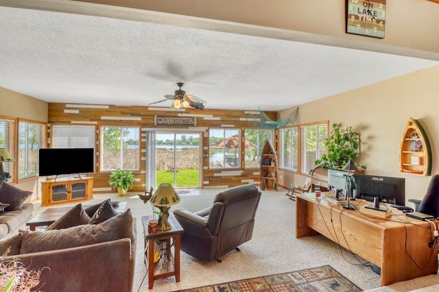 25934 Brolin Beach Rd, Detroit Twp, MN 56501 - carpeted living room featuring wooden walls, ceiling fan, healthy amount of natural light, and a textured ceiling