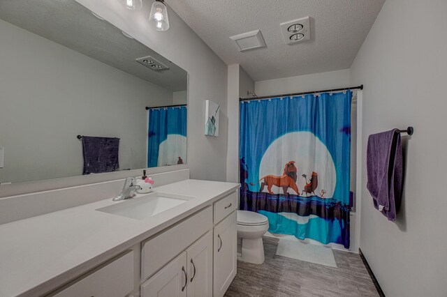 17690 Clayton Ave E, Vermillion Twp, MN 55068 - full bathroom with toilet, vanity, wood finished floors, a textured ceiling, and a shower with shower curtain