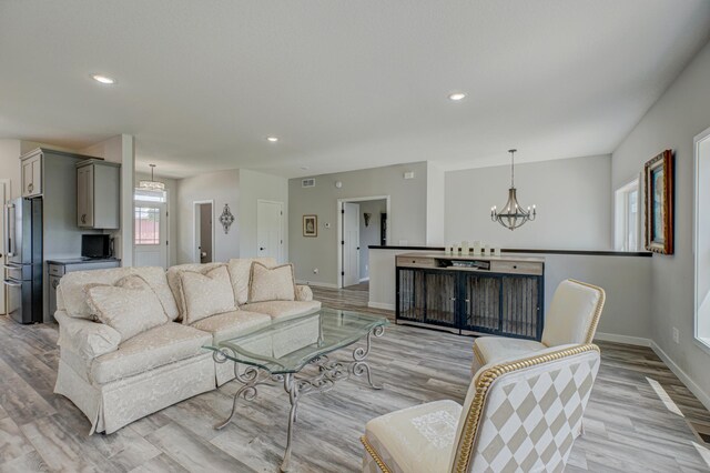 17690 Clayton Ave E, Vermillion Twp, MN 55068 - living room featuring a chandelier, light wood finished floors, baseboards, and recessed lighting