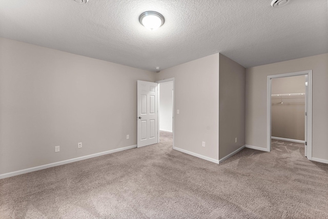 14111 Abercorn Ave, Rosemount, MN 55068 - unfurnished bedroom featuring carpet, a walk in closet, baseboards, a textured ceiling, and a closet