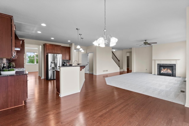 14111 Abercorn Ave, Rosemount, MN 55068 - kitchen featuring dark countertops, stainless steel refrigerator with ice dispenser, a ceiling fan, a tiled fireplace, and dark wood-type flooring