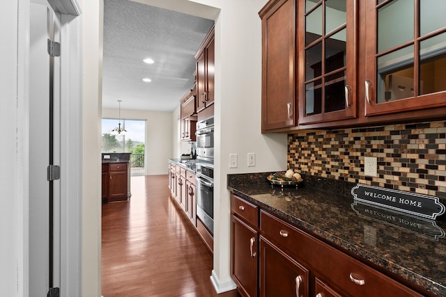 14111 Abercorn Ave, Rosemount, MN 55068 - kitchen with decorative backsplash, dark wood-style floors, glass insert cabinets, dark stone countertops, and a textured ceiling