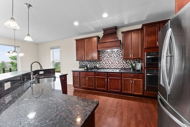 14111 Abercorn Ave, Rosemount, MN 55068 - kitchen featuring stainless steel appliances, custom range hood, a sink, decorative light fixtures, and dark wood-style flooring