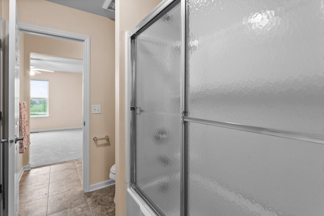 14111 Abercorn Ave, Rosemount, MN 55068 - full bathroom featuring toilet, combined bath / shower with glass door, baseboards, tile patterned flooring, and ceiling fan