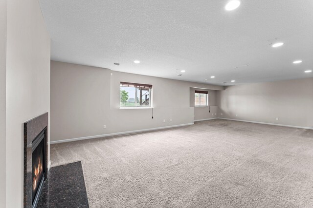 14111 Abercorn Ave, Rosemount, MN 55068 - unfurnished living room featuring recessed lighting, a fireplace with flush hearth, carpet floors, a textured ceiling, and baseboards