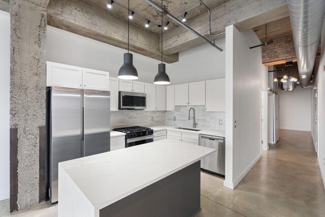 901 3rd St Unit 515, Minneapolis, MN 55401 - kitchen with stainless steel appliances, a sink, a kitchen island, backsplash, and a towering ceiling