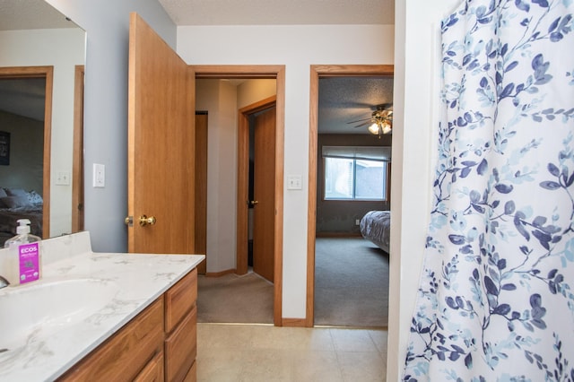 1810 41st Ave S, Moorhead, MN 56560 - ensuite bathroom with a ceiling fan, vanity, tile patterned floors, a textured ceiling, and baseboards