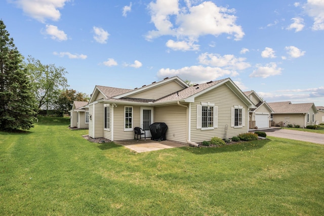 12 3rd St NW, Saint Michael, MN 55376 - back of property with driveway, a yard, a shingled roof, a garage, and a patio area