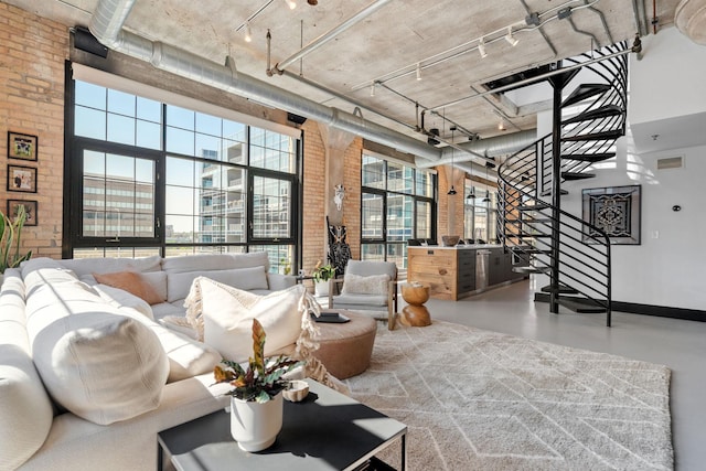 525 3rd St N Unit 511, Minneapolis, MN 55401 - living area with a towering ceiling, rail lighting, stairway, brick wall, and finished concrete flooring