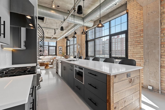 525 3rd St N Unit 511, Minneapolis, MN 55401 - kitchen featuring brick wall, high end stainless steel range, a towering ceiling, modern cabinets, and finished concrete flooring