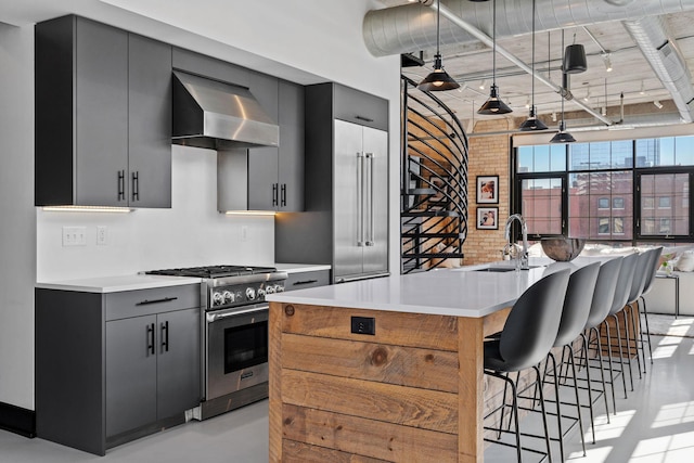 525 3rd St N Unit 511, Minneapolis, MN 55401 - kitchen featuring wall chimney range hood, stainless steel range, a breakfast bar, and light countertops