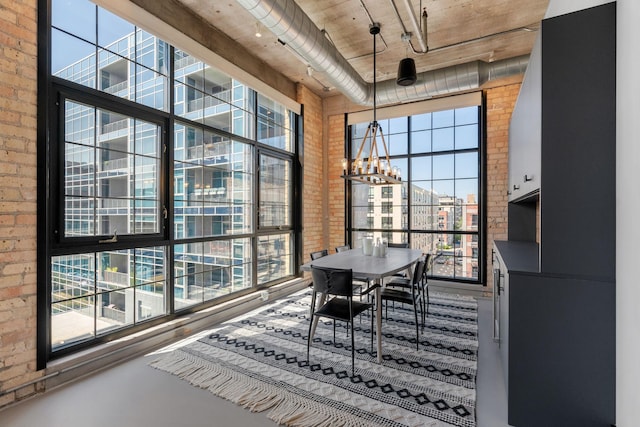 525 3rd St N Unit 511, Minneapolis, MN 55401 - dining area featuring brick wall, a chandelier, healthy amount of natural light, and a high ceiling