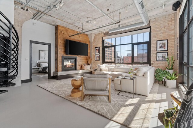 525 3rd St N Unit 511, Minneapolis, MN 55401 - living area with a high ceiling, brick wall, a glass covered fireplace, and finished concrete flooring