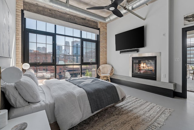 525 3rd St N Unit 511, Minneapolis, MN 55401 - bedroom with a glass covered fireplace, finished concrete floors, multiple windows, and ceiling fan
