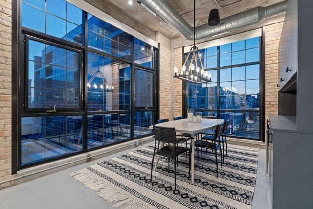 525 3rd St N Unit 511, Minneapolis, MN 55401 - dining space featuring brick wall, a chandelier, and a towering ceiling