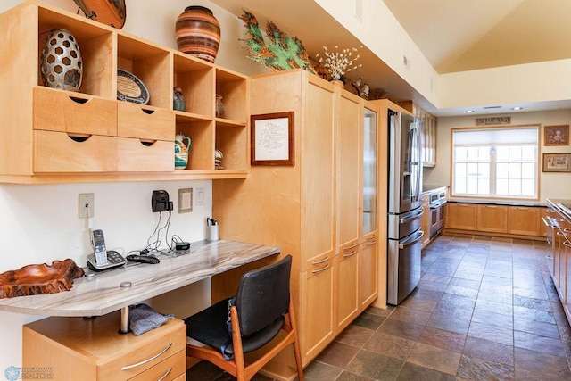 404 8th St S Unit 303, Fargo, ND 58103 - kitchen featuring stone tile floors, stainless steel fridge, light brown cabinets, vaulted ceiling, and light countertops