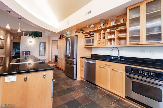 404 8th St S Unit 303, Fargo, ND 58103 - kitchen featuring stainless steel appliances, a sink, light brown cabinetry, dark countertops, and dark stone finish floors