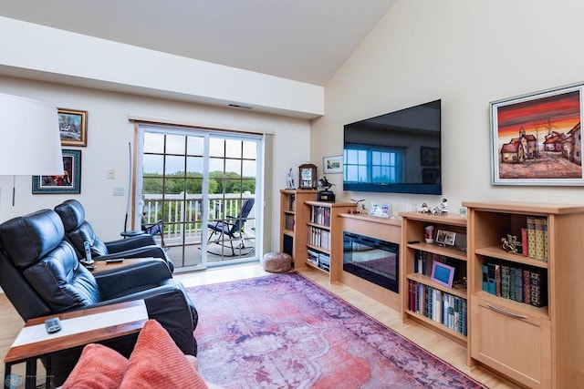 404 8th St S Unit 303, Fargo, ND 58103 - living area featuring light wood-type flooring, a glass covered fireplace, and high vaulted ceiling