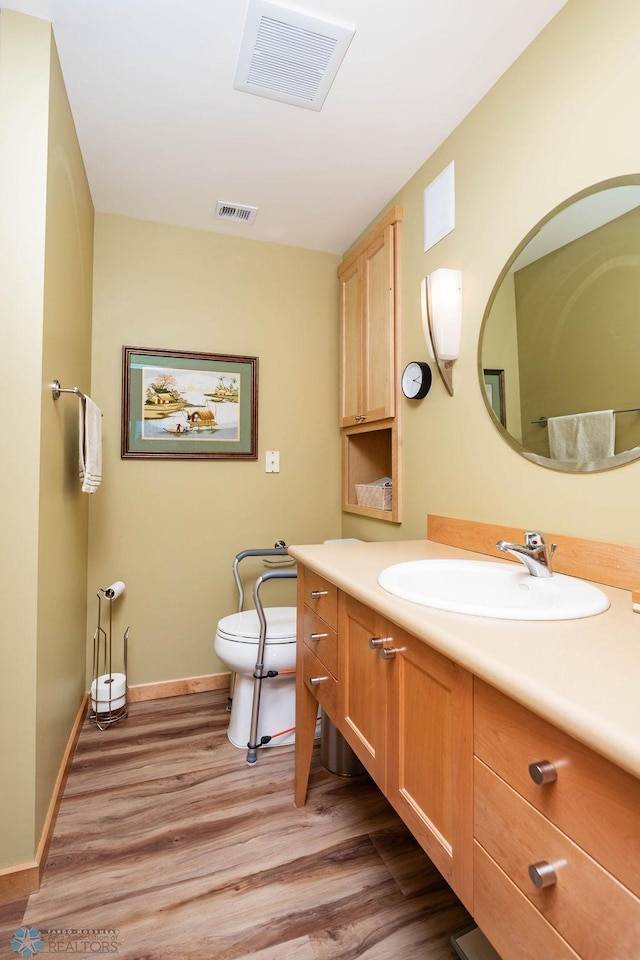 404 8th St S Unit 303, Fargo, ND 58103 - bathroom featuring toilet, wood finished floors, vanity, and baseboards
