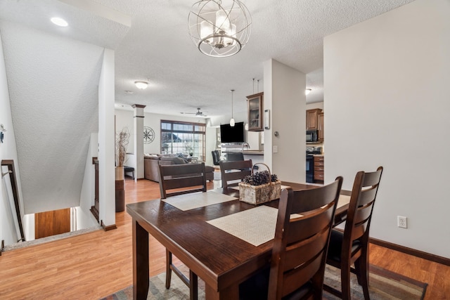 6665 Flycatcher Ln, Apple Valley, MN 55124 - dining space featuring light wood-style flooring, a textured ceiling, baseboards, ceiling fan, and a chandelier