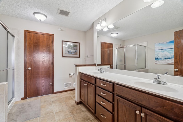 6665 Flycatcher Ln, Apple Valley, MN 55124 - full bath featuring double vanity, a stall shower, toilet, a textured ceiling, and baseboards