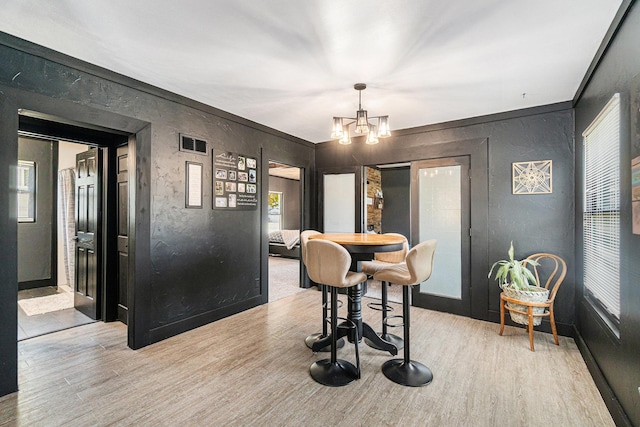 506 8th Ave SW, Pipestone, MN 56164 - dining area featuring light wood finished floors, a chandelier, baseboards, and a textured wall