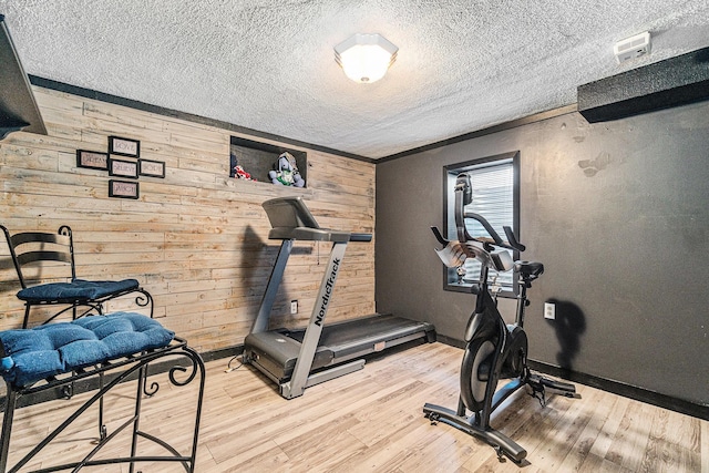 506 8th Ave SW, Pipestone, MN 56164 - workout area with wood walls, light wood-type flooring, baseboards, and a textured ceiling