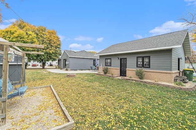 506 8th Ave SW, Pipestone, MN 56164 - rear view of property with brick siding, a yard, roof with shingles, and a patio