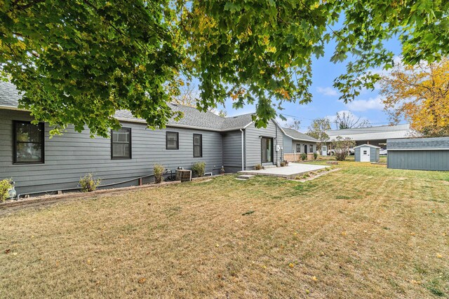 506 8th Ave SW, Pipestone, MN 56164 - back of property featuring a patio, a yard, central AC unit, and roof with shingles