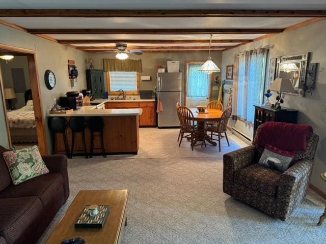 48408 Pillar Rd, Deer River, MN 56631 - living room with beam ceiling, ceiling fan, light colored carpet, and baseboard heating