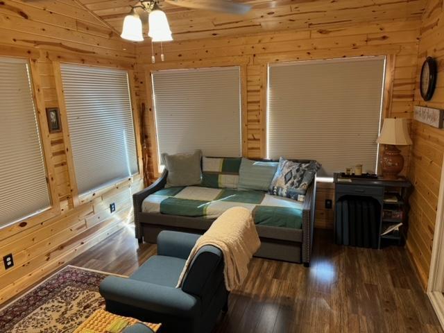 48408 Pillar Rd, Deer River, MN 56631 - living room featuring wooden walls, ceiling fan, and wood finished floors