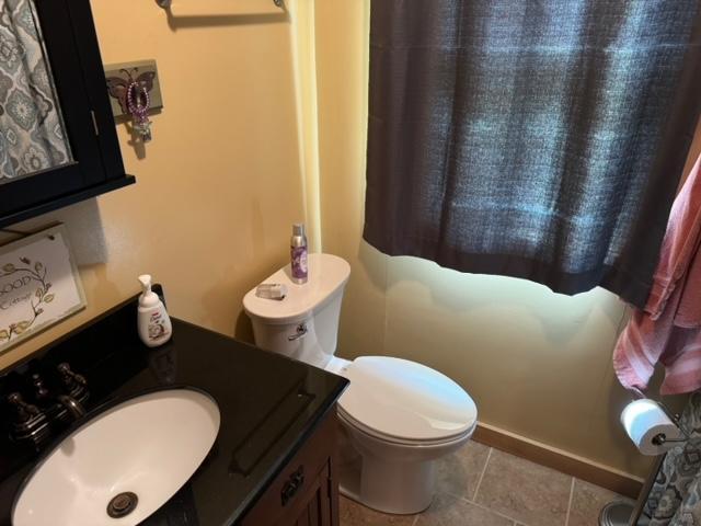 48408 Pillar Rd, Deer River, MN 56631 - bathroom with tile patterned flooring, toilet, baseboards, and vanity