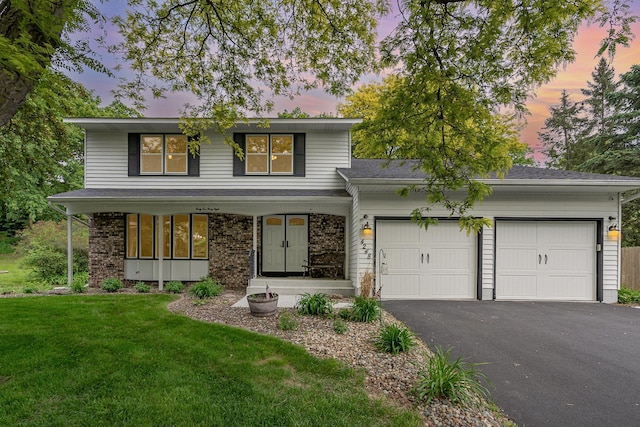 4248 Westview Dr, Shoreview, MN 55126 - view of front of property featuring a garage, asphalt driveway, a front lawn, covered porch, and roof with shingles