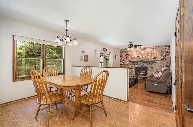 4248 Westview Dr, Shoreview, MN 55126 - dining room featuring light wood-style floors, a chandelier, a brick fireplace, ceiling fan, and baseboards