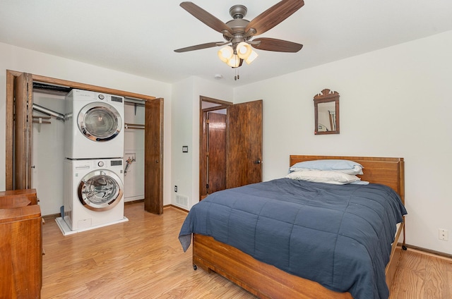 4248 Westview Dr, Shoreview, MN 55126 - bedroom featuring stacked washer / dryer, light wood-type flooring, baseboards, ceiling fan, and a closet