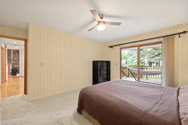 2725 Pilgrim Ln N, Plymouth, MN 55441 - bedroom featuring access to outside, wooden walls, a ceiling fan, and light carpet