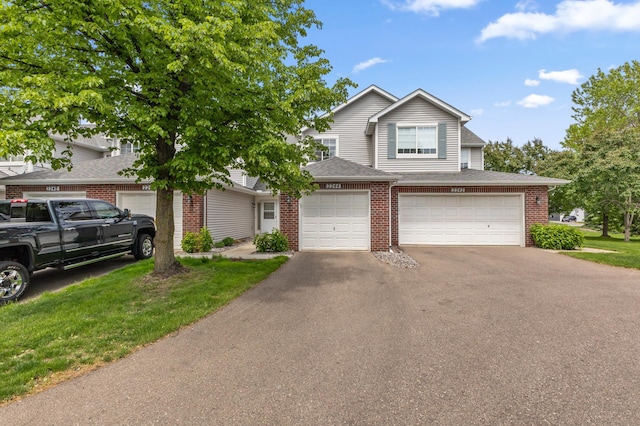2244 Water Lilly Ln Unit 405, Eagan, MN 55122 - view of front of home with brick siding, asphalt driveway, a garage, and roof with shingles