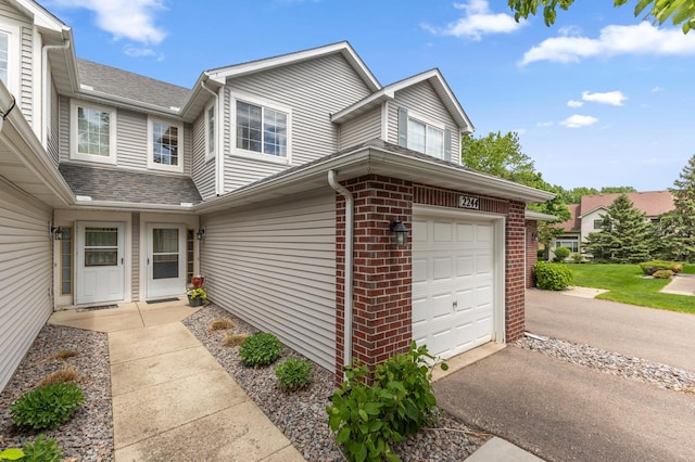 2244 Water Lilly Ln Unit 405, Eagan, MN 55122 - view of home's exterior featuring a garage, brick siding, and asphalt driveway