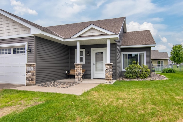 411 Ladd Ln, Osceola, WI 54020 - view of front of house featuring a shingled roof, stone siding, a porch, and an attached garage