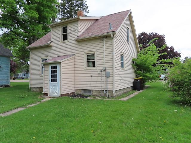 529 1st St N, Truman, MN 56088 - back of house featuring a chimney, a yard, and roof with shingles