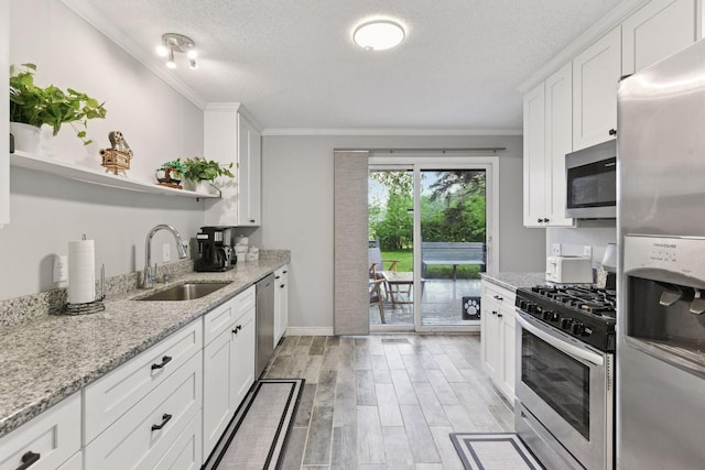 2505 Florida Ave N, Golden Valley, MN 55427 - kitchen featuring appliances with stainless steel finishes, a sink, open shelves, light wood-style flooring, and white cabinets