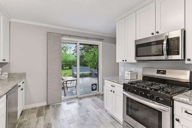 2505 Florida Ave N, Golden Valley, MN 55427 - kitchen with appliances with stainless steel finishes, crown molding, light wood-style floors, white cabinets, and light stone countertops