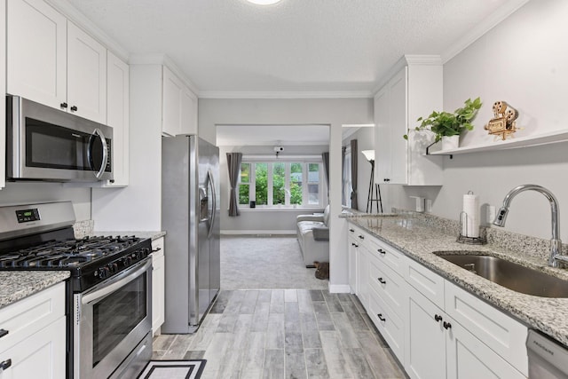 2505 Florida Ave N, Golden Valley, MN 55427 - kitchen featuring stainless steel appliances, a sink, light wood finished floors, white cabinetry, and crown molding