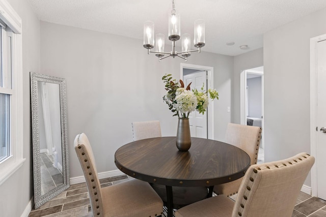 2505 Florida Ave N, Golden Valley, MN 55427 - dining room featuring a chandelier, wood finish floors, baseboards, and a textured ceiling