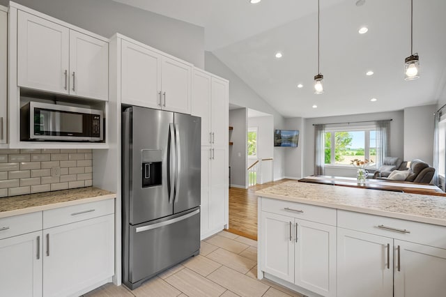 975 100th St NE, Monticello Twp, MN 55362 - kitchen with stainless steel appliances, open floor plan, decorative backsplash, lofted ceiling, and recessed lighting