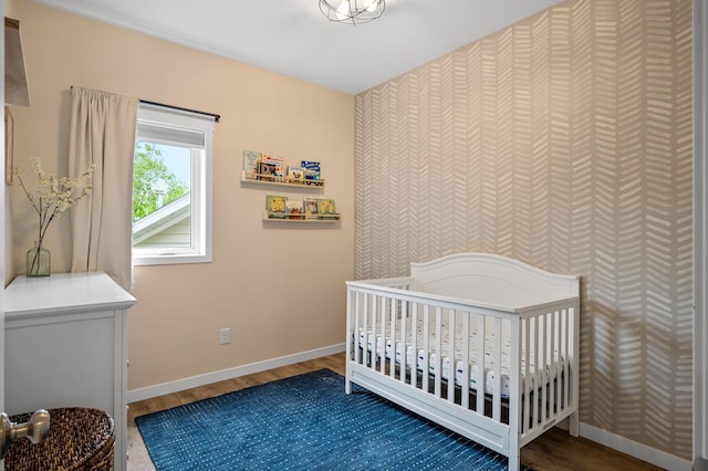975 100th St NE, Monticello Twp, MN 55362 - bedroom featuring wood finished floors, baseboards, and a crib