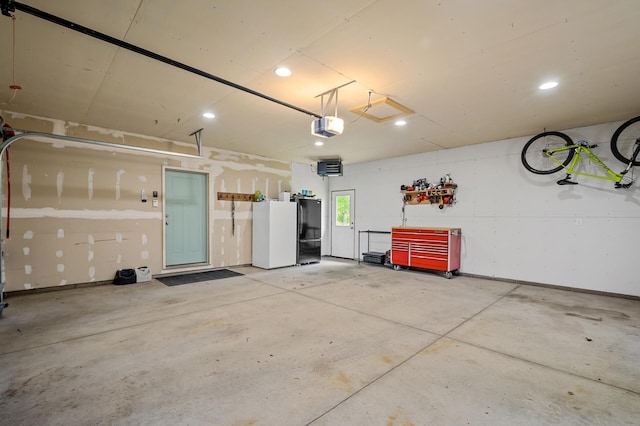 975 100th St NE, Monticello Twp, MN 55362 - garage with a garage door opener, freestanding refrigerator, and recessed lighting