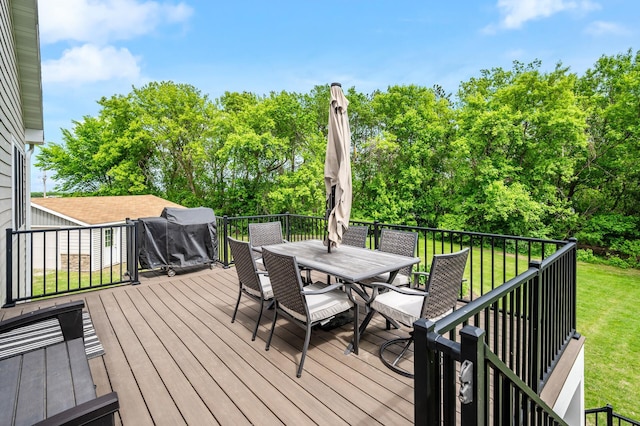975 100th St NE, Monticello Twp, MN 55362 - wooden deck featuring outdoor dining area, a lawn, and view of scattered trees
