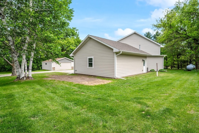 975 100th St NE, Monticello Twp, MN 55362 - back of property featuring a lawn, an outbuilding, and roof with shingles